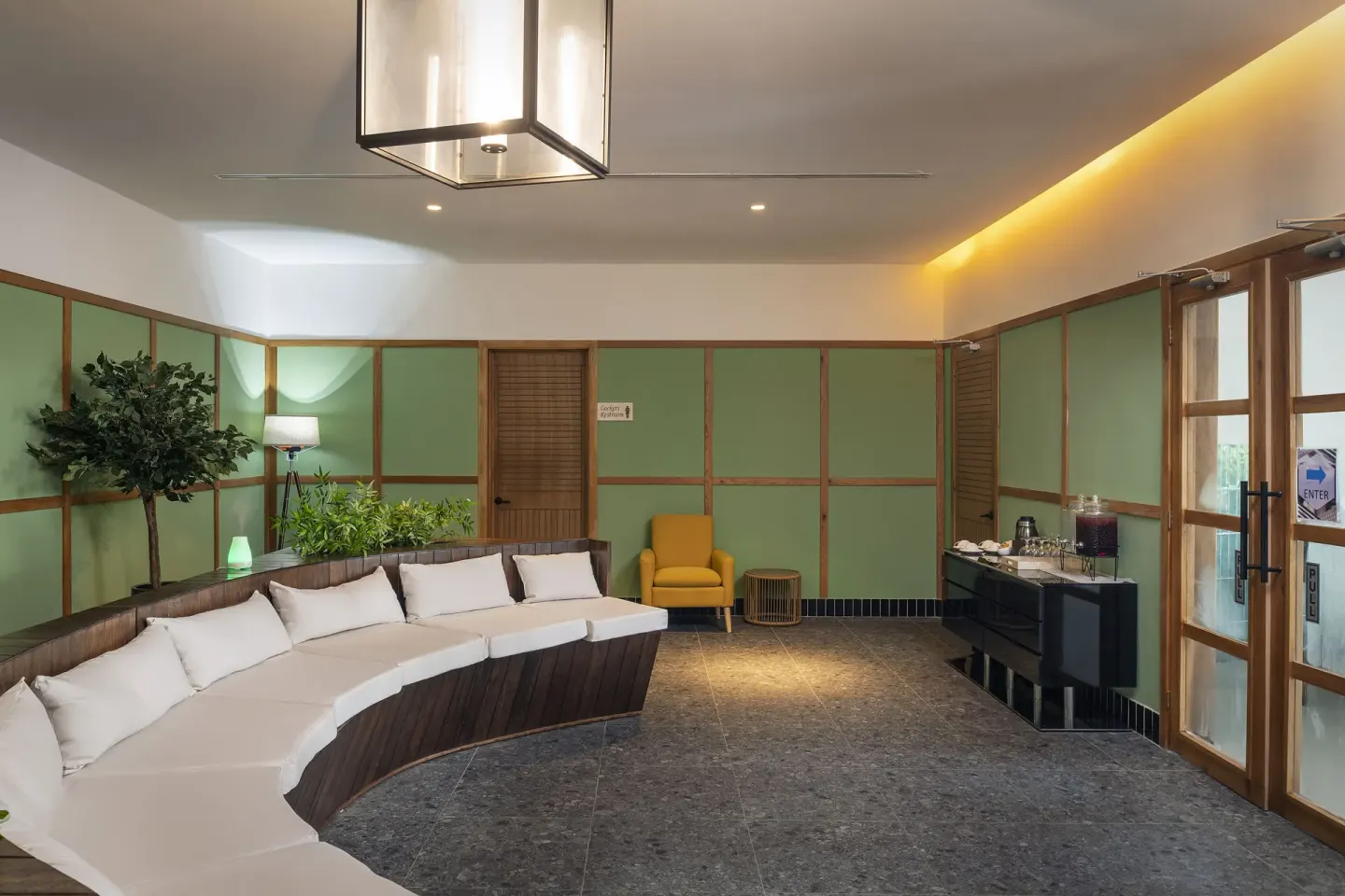 Spa lounge with curved white seating and green paneled walls at Ocean Eden Bay.