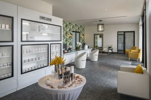 Spa reception area with product displays and lounge seating at Ocean Eden Bay.