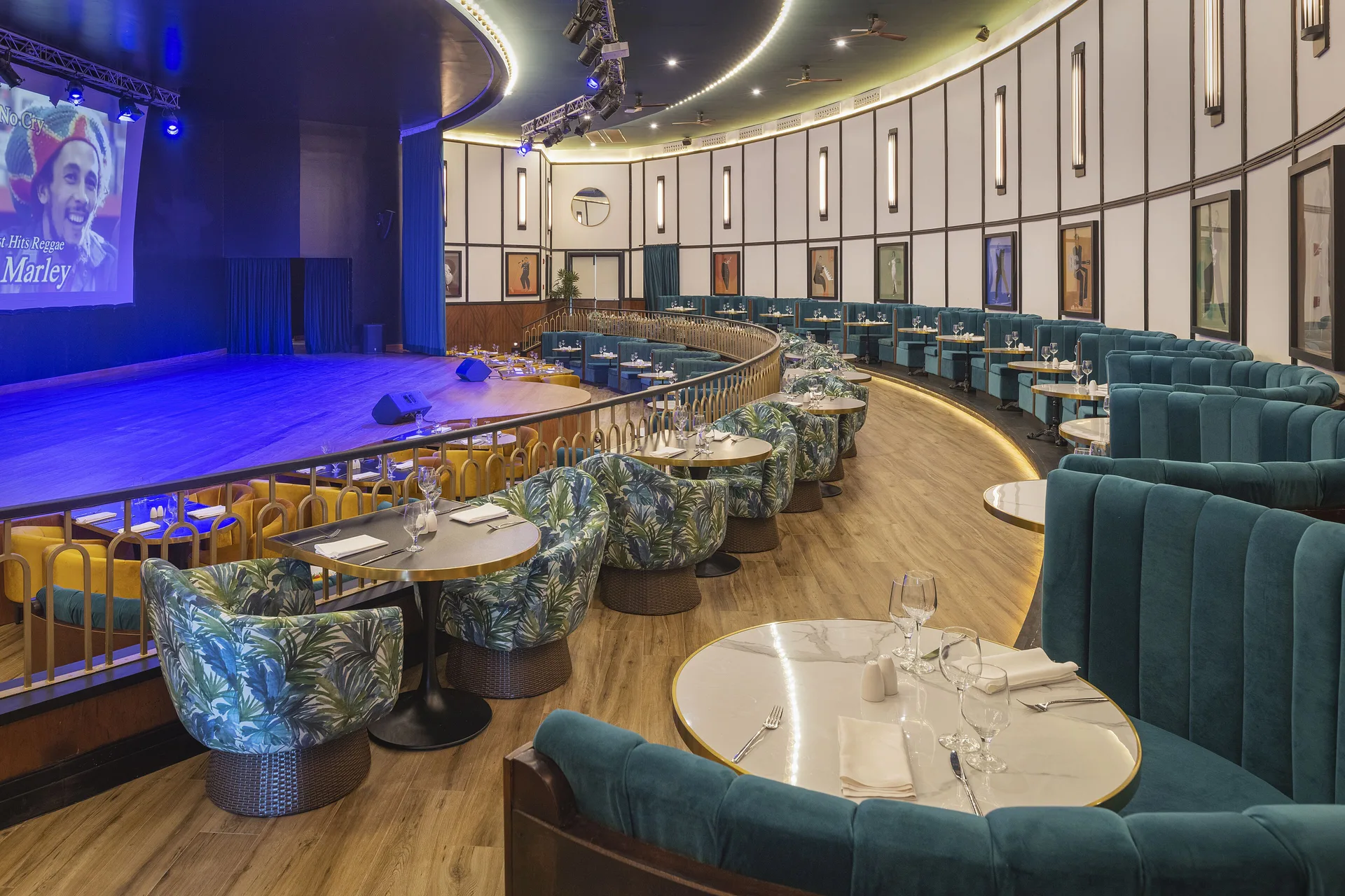 Dinner show venue with stage, curved seating, and set tables at Ocean Eden Bay.