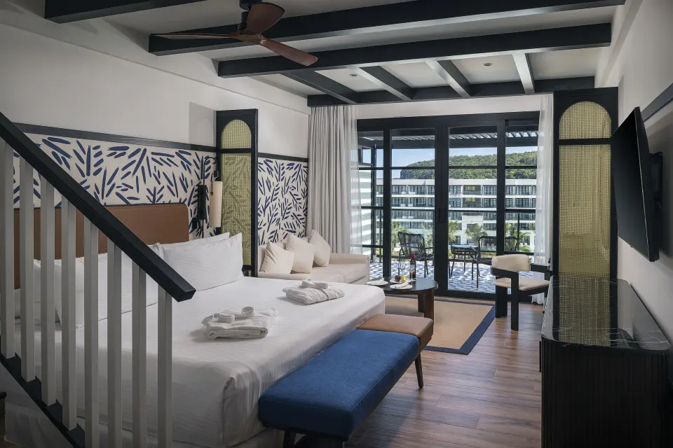 Privilege Junior Suite Rooftop king bed and lounge area at Ocean Eden Bay.