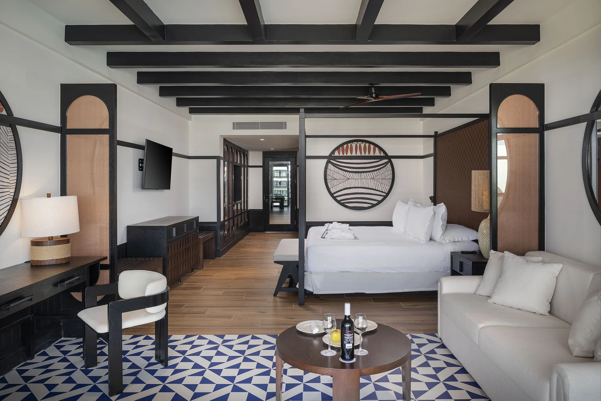 Privilege Junior Suite Swim Up room with king bed, sofa and desk at Ocean Eden Bay.