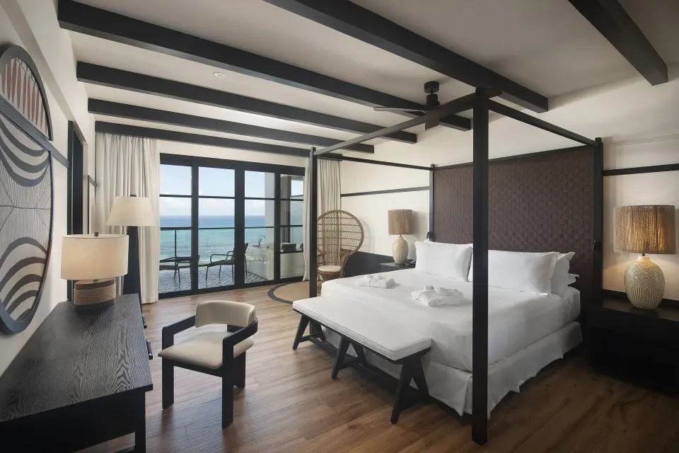 Privilege Master Suite Ocean Eden Bay bedroom with four-poster bed and sea view at Ocean Eden Bay.