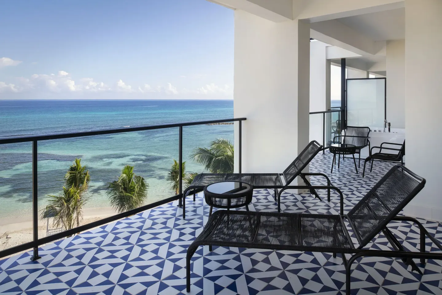 Privilege Master Suite Ocean Eden Bay balcony with loungers and sea view at Ocean Eden Bay.