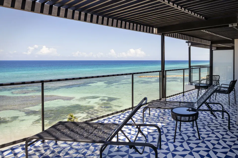 Privilege Master Suite oceanfront balcony with loungers at Ocean Eden Bay.