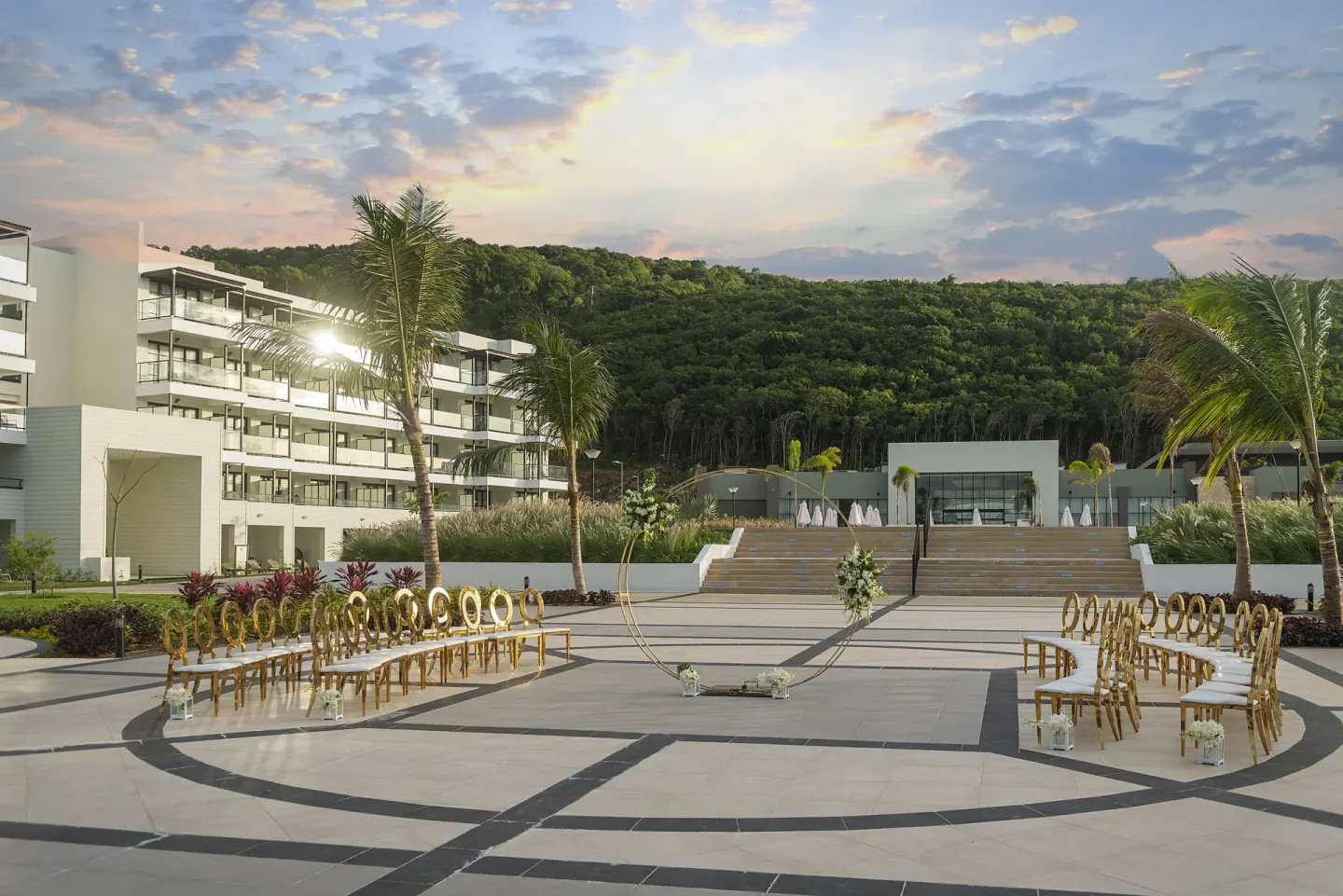 An outdoor wedding ceremony setup with gold chairs and floral decor at Ocean Eden Bay.