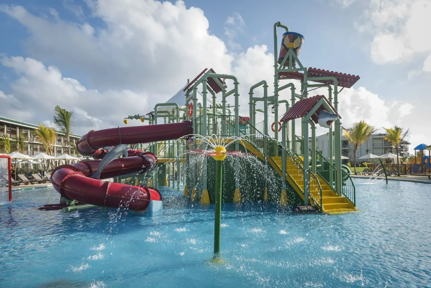 Aquatic playground with red tube slides at Ocean El Faro Resort.