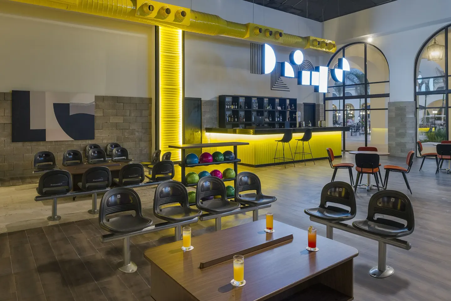 Bowling lounge with seating, colorful balls, and a bar at Ocean El Faro Resort.