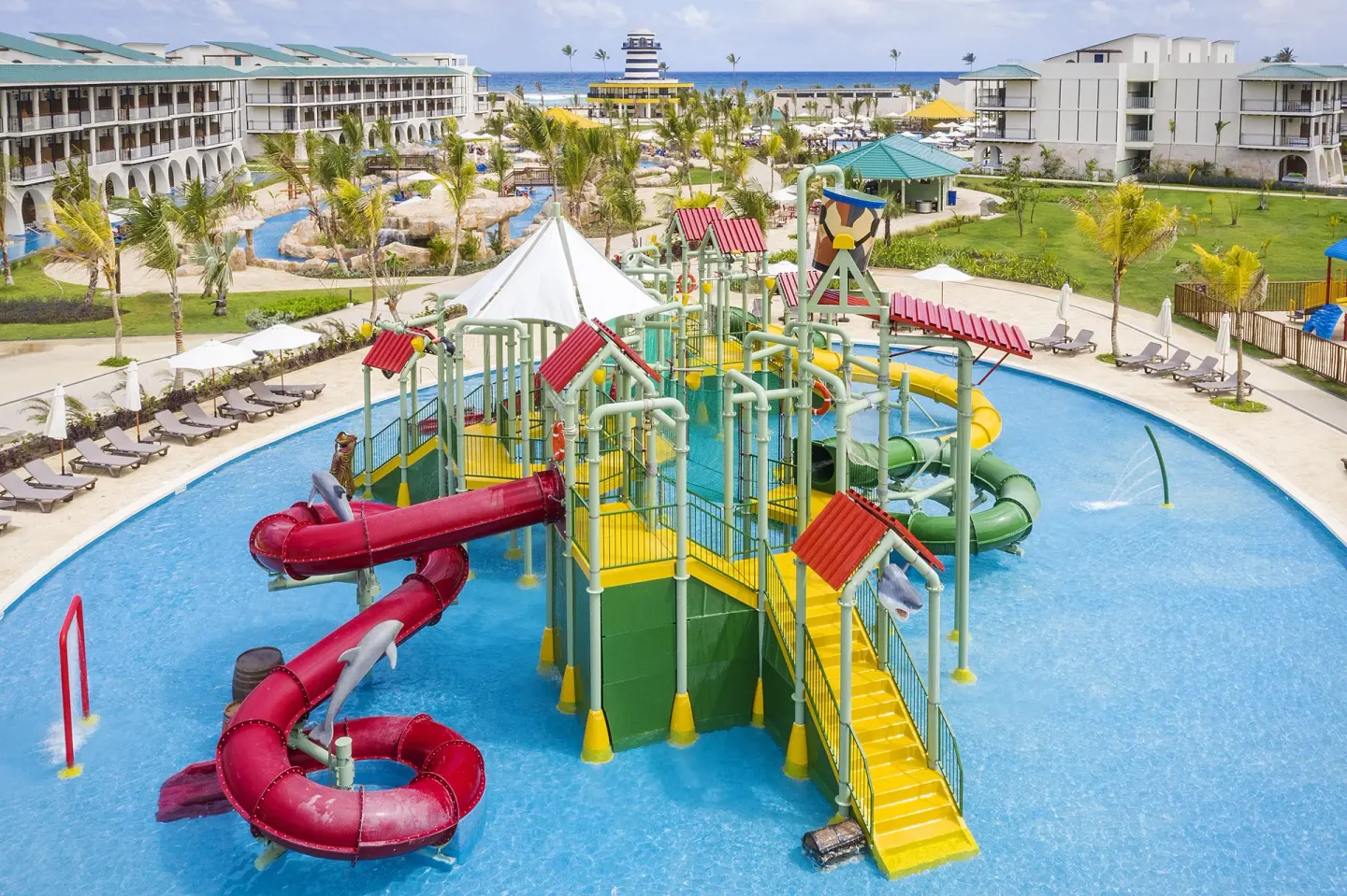 Children's water play area with slides and resort buildings at Ocean El Faro Resort.
