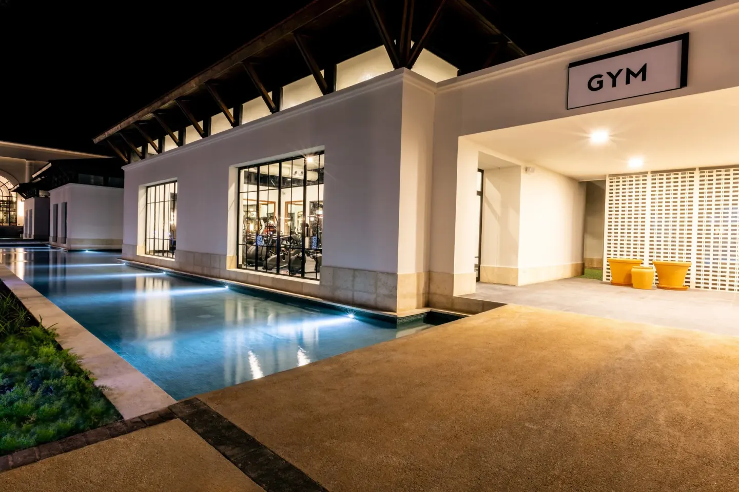 Night view of the gym entrance beside a lit pool at Ocean El Faro Resort.