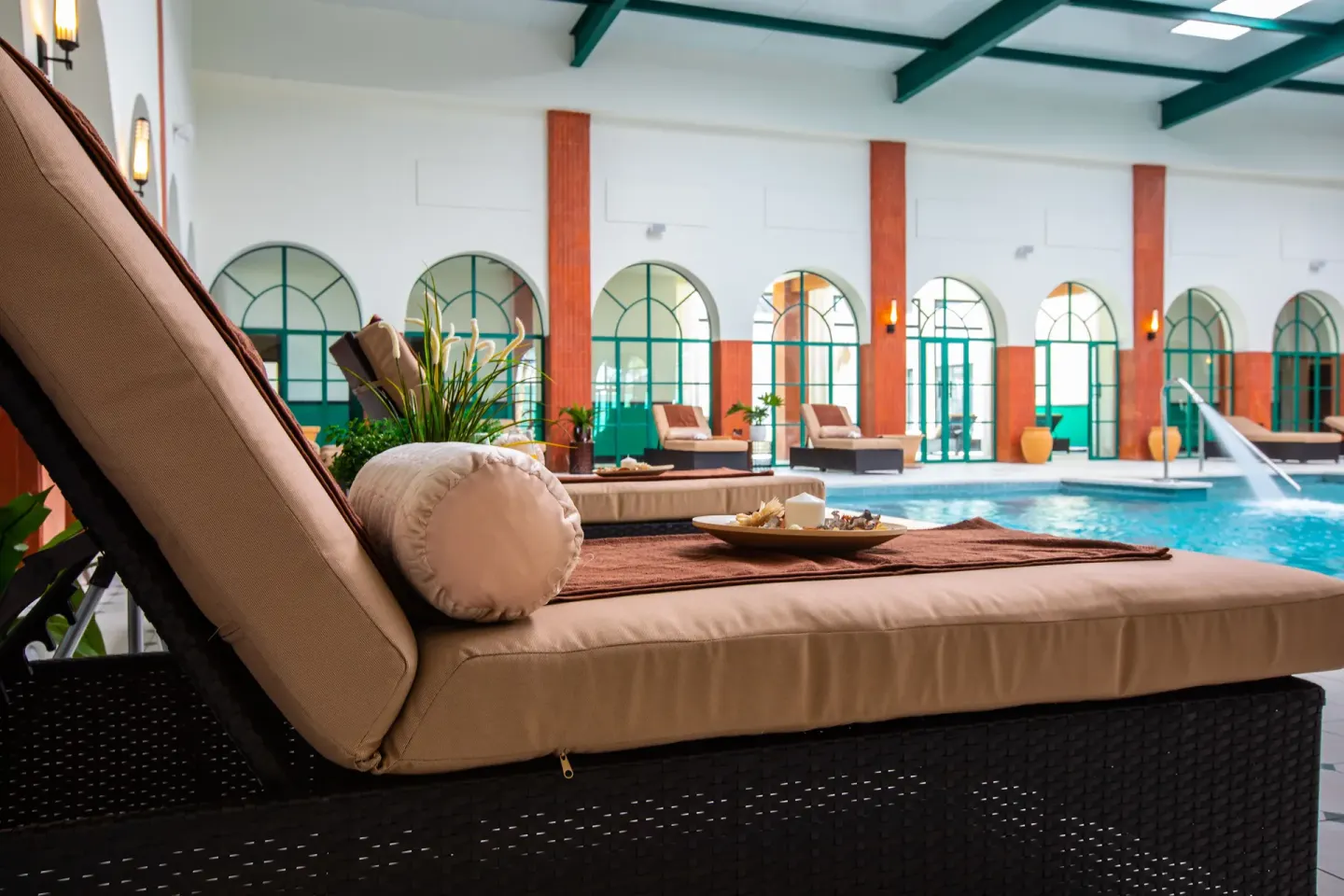 Cushioned lounger beside an indoor spa pool at Ocean El Faro Resort.