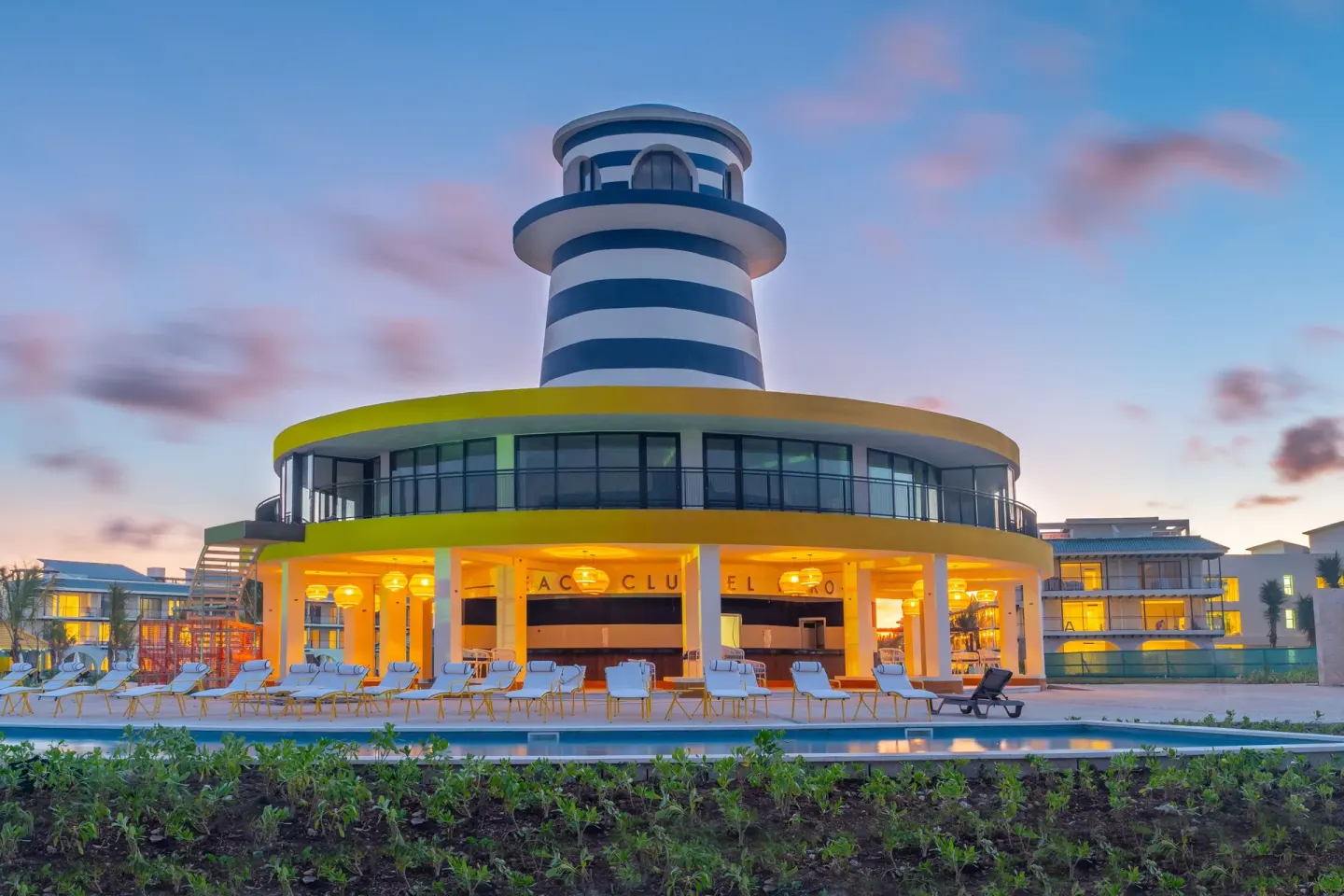 Lighthouse-style poolside building at dusk at Ocean El Faro Resort.