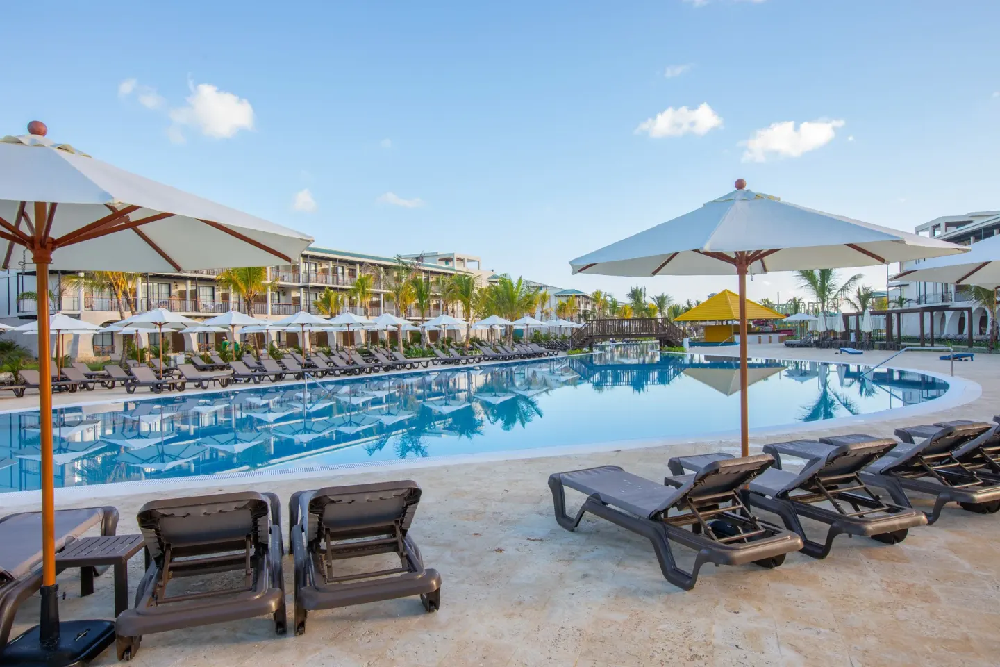 Large resort pool with umbrellas and loungers at Ocean El Faro Resort.
