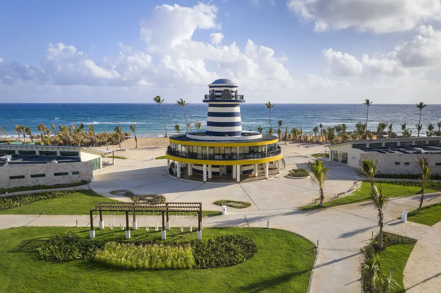 Oceanfront lighthouse-style building and landscaped paths at Ocean El Faro Resort.