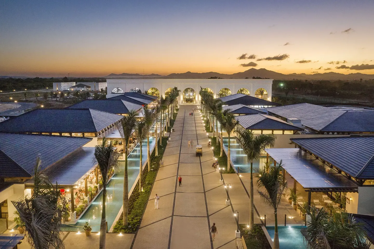 Illuminated resort promenade at sunset at Ocean El Faro Resort.