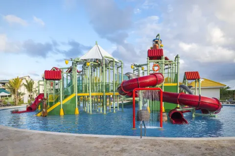 Water park play structure with red slides at Ocean El Faro Resort.
