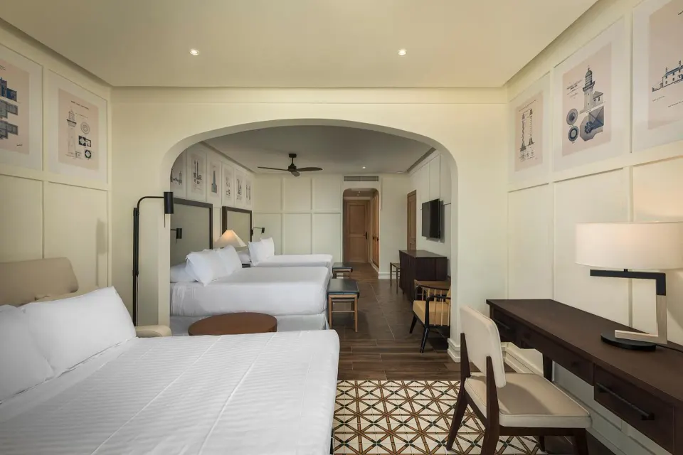 Junior Suite Nature View at Ocean El Faro Resort showing a sofa bed, desk, and two beds in back.