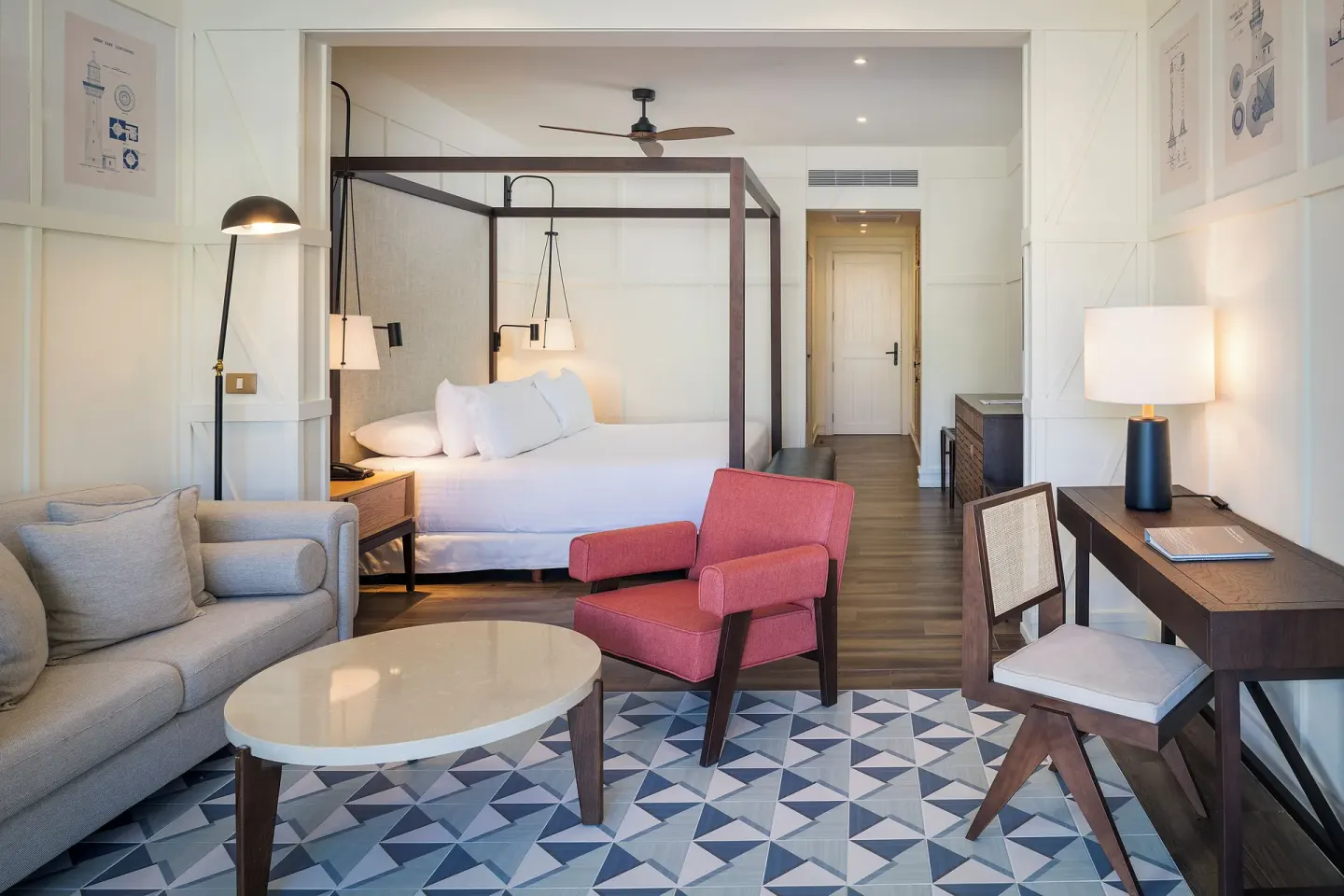 Junior Suite Nature View with king bed, sofa, desk and red chair at Ocean El Faro Resort.