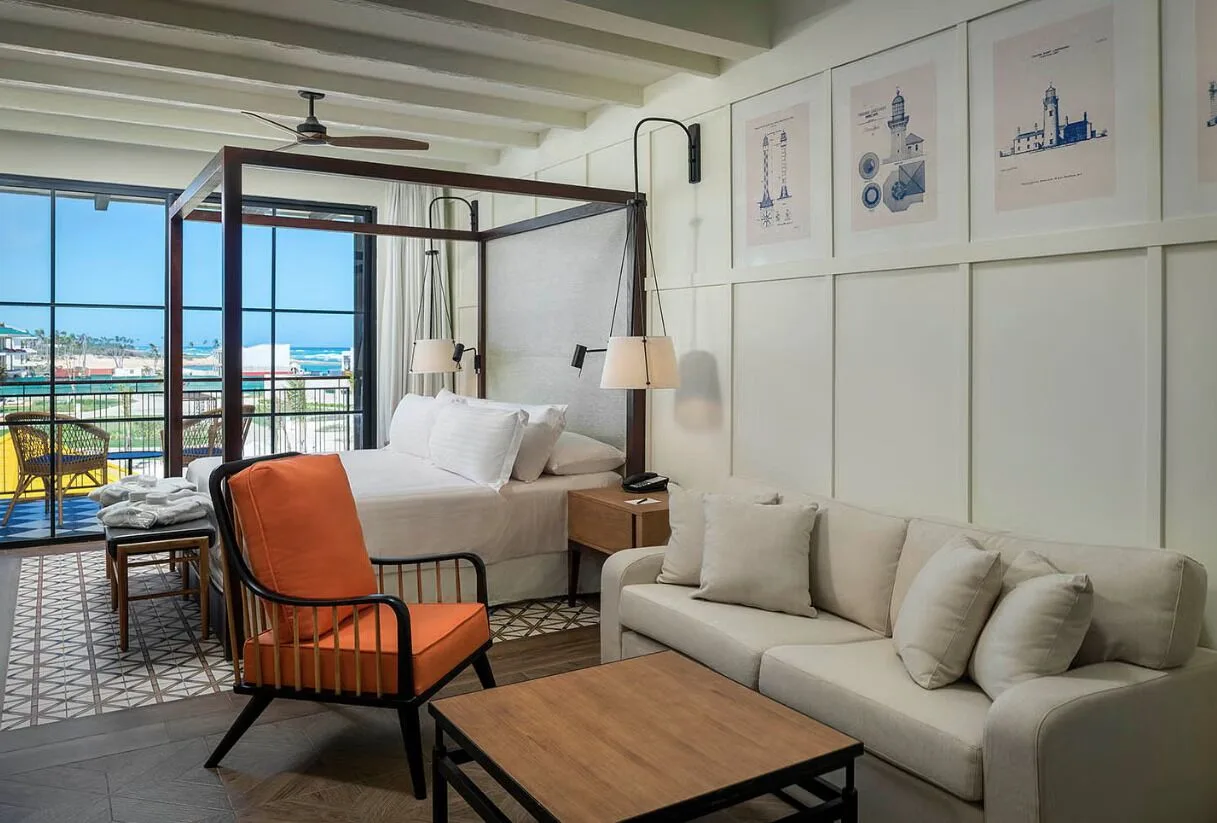 Suite seating area with canopy bed and balcony ocean view at Ocean El Faro Resort.