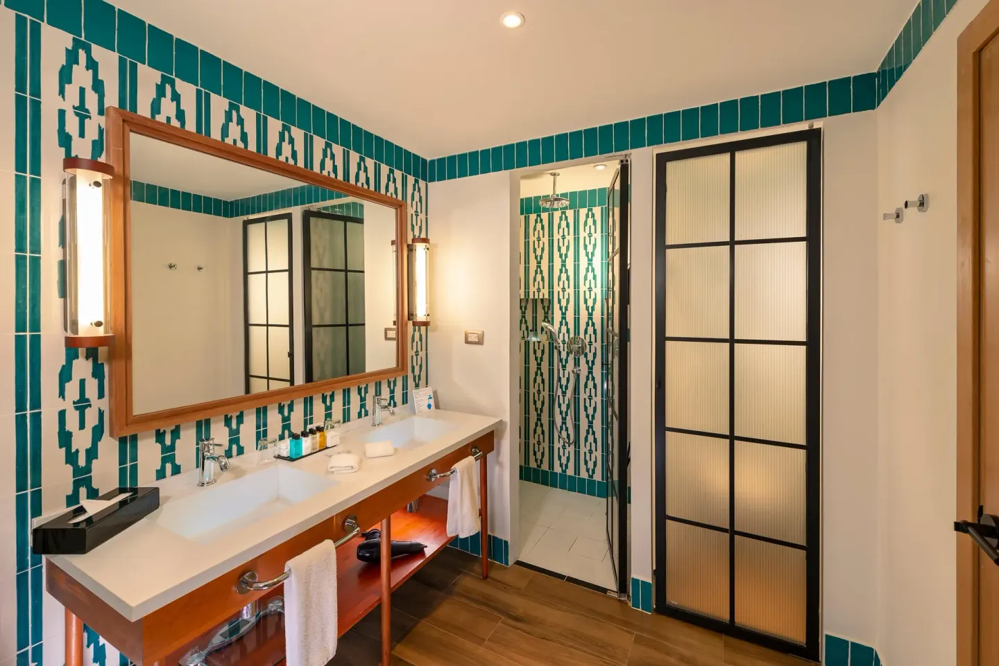 Junior room bathroom with double vanity and glass shower at Ocean El Faro Resort.