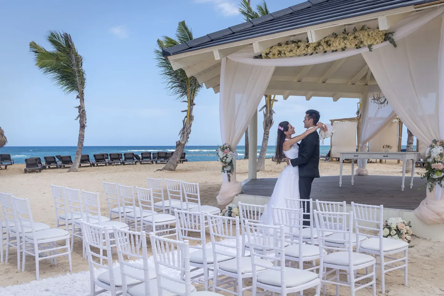 Bride and groom at a beachfront wedding gazebo at Ocean El Faro Resort.
