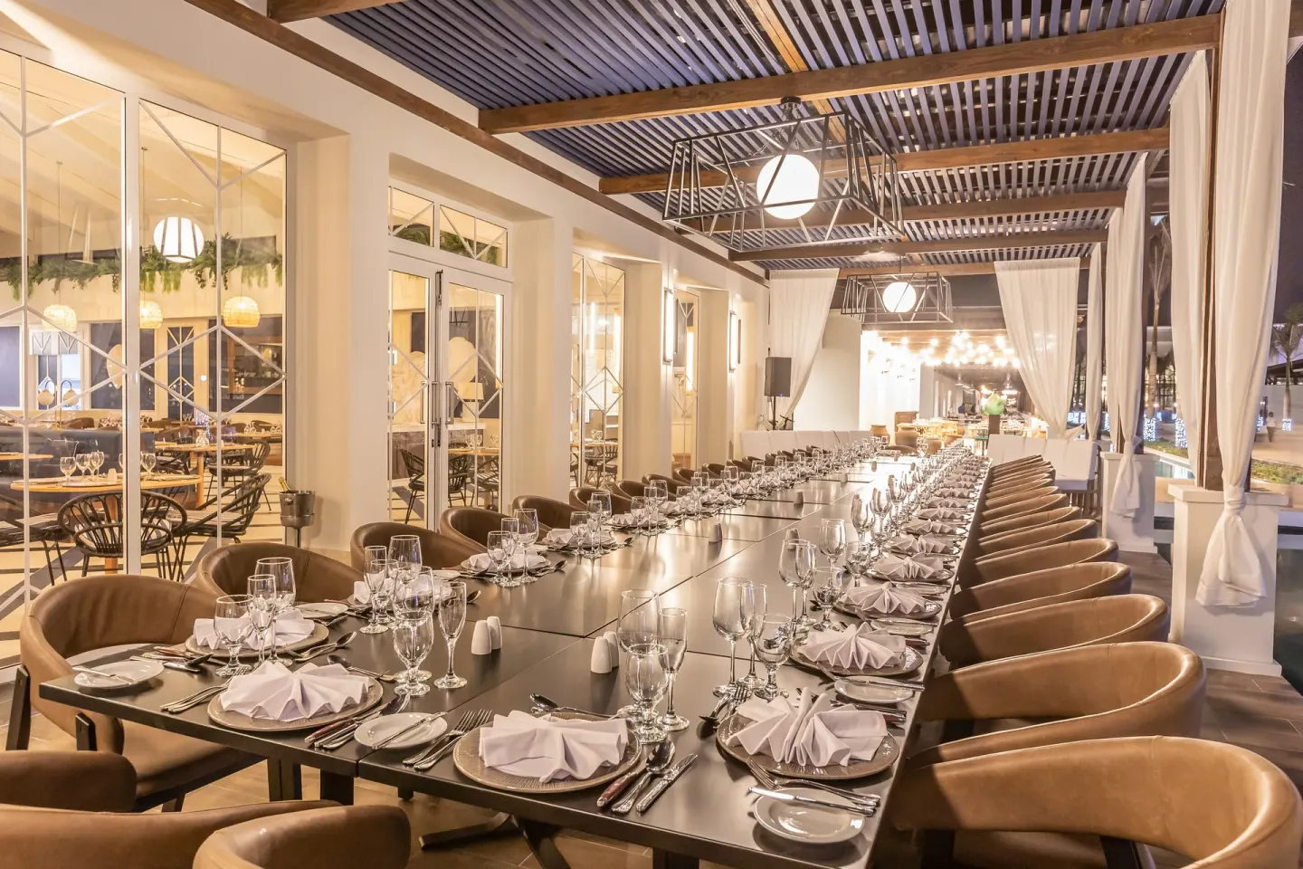 Long outdoor event table set with glassware at Ocean El Faro Resort.