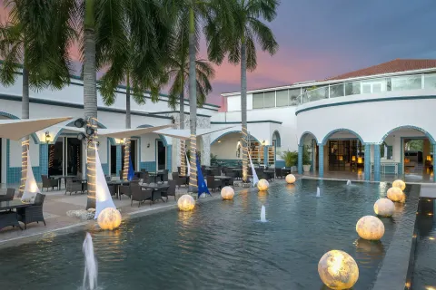 Palm-lined courtyard fountain and terrace seating at Ocean Maya Royale.