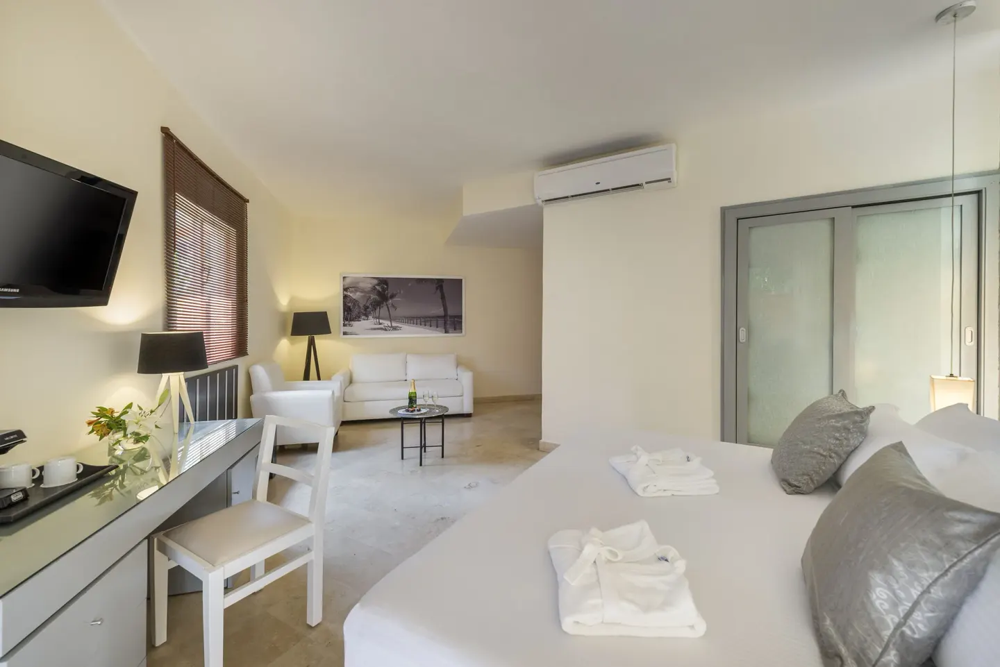 Spacious king bed guest room with sitting area and desk at Ocean Maya Royale.