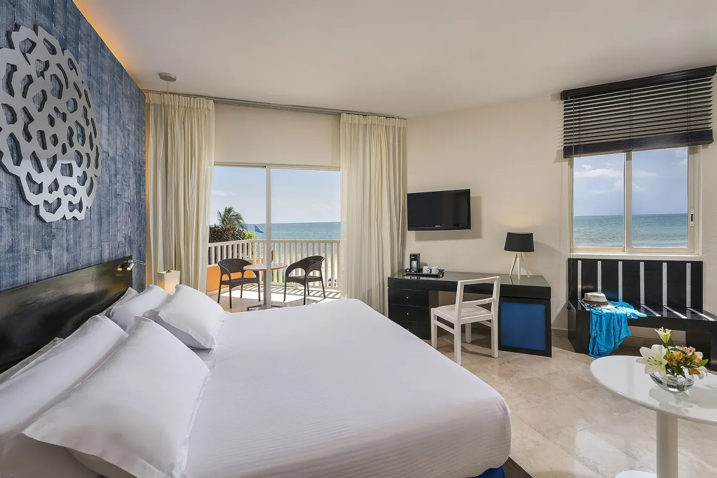 Ocean-view guest room with king bed and balcony at Ocean Maya Royale.