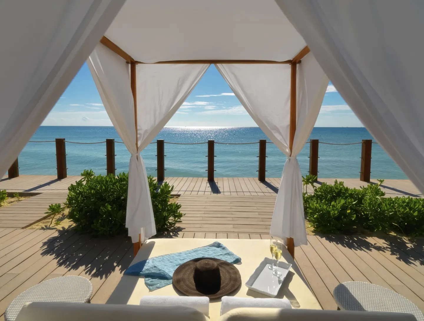 Oceanfront cabana with lounge bed and sea view at Ocean Maya Royale.