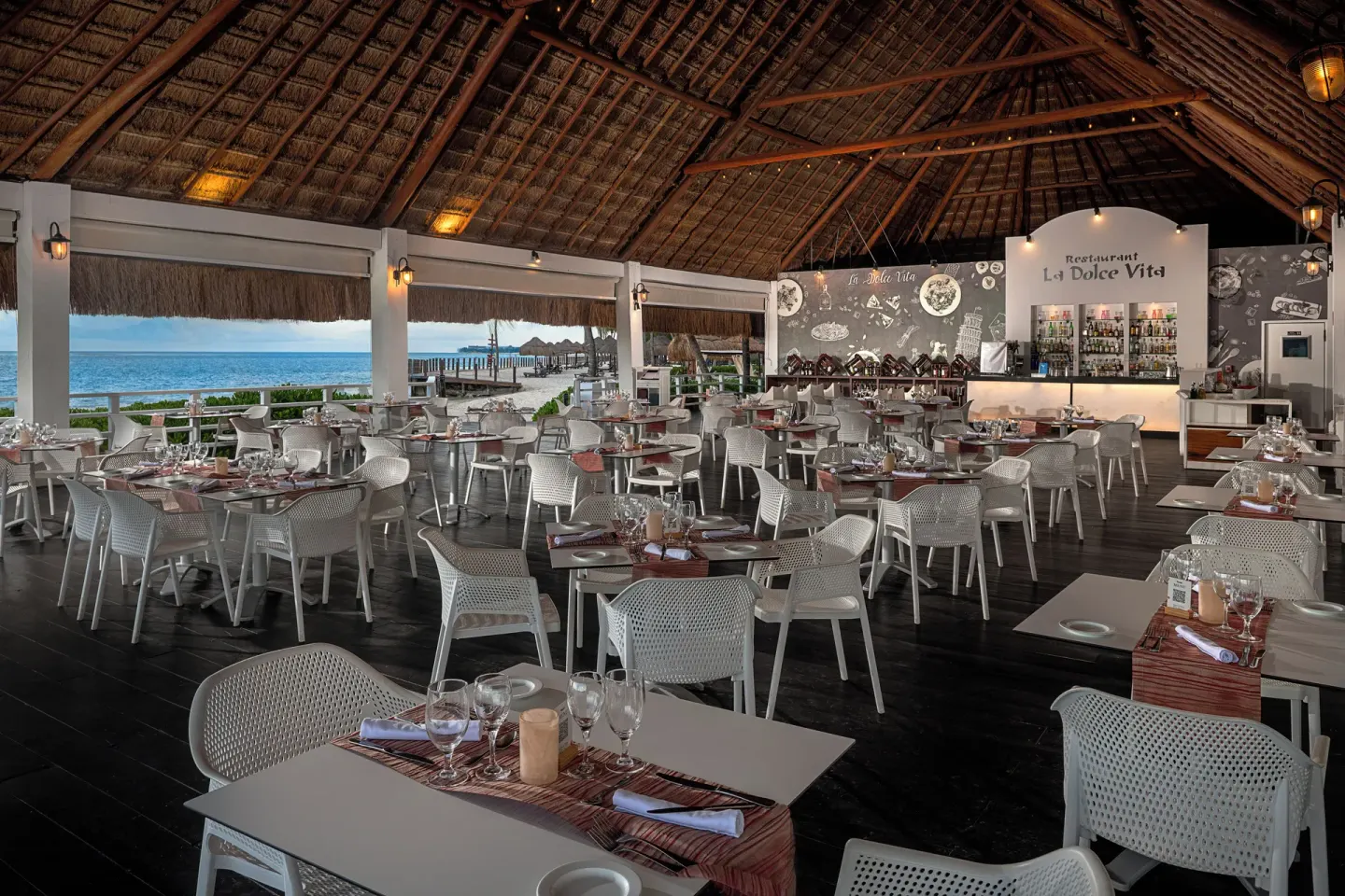 Dolce Vita dining room with ocean views and a bar at Ocean Maya Royale.