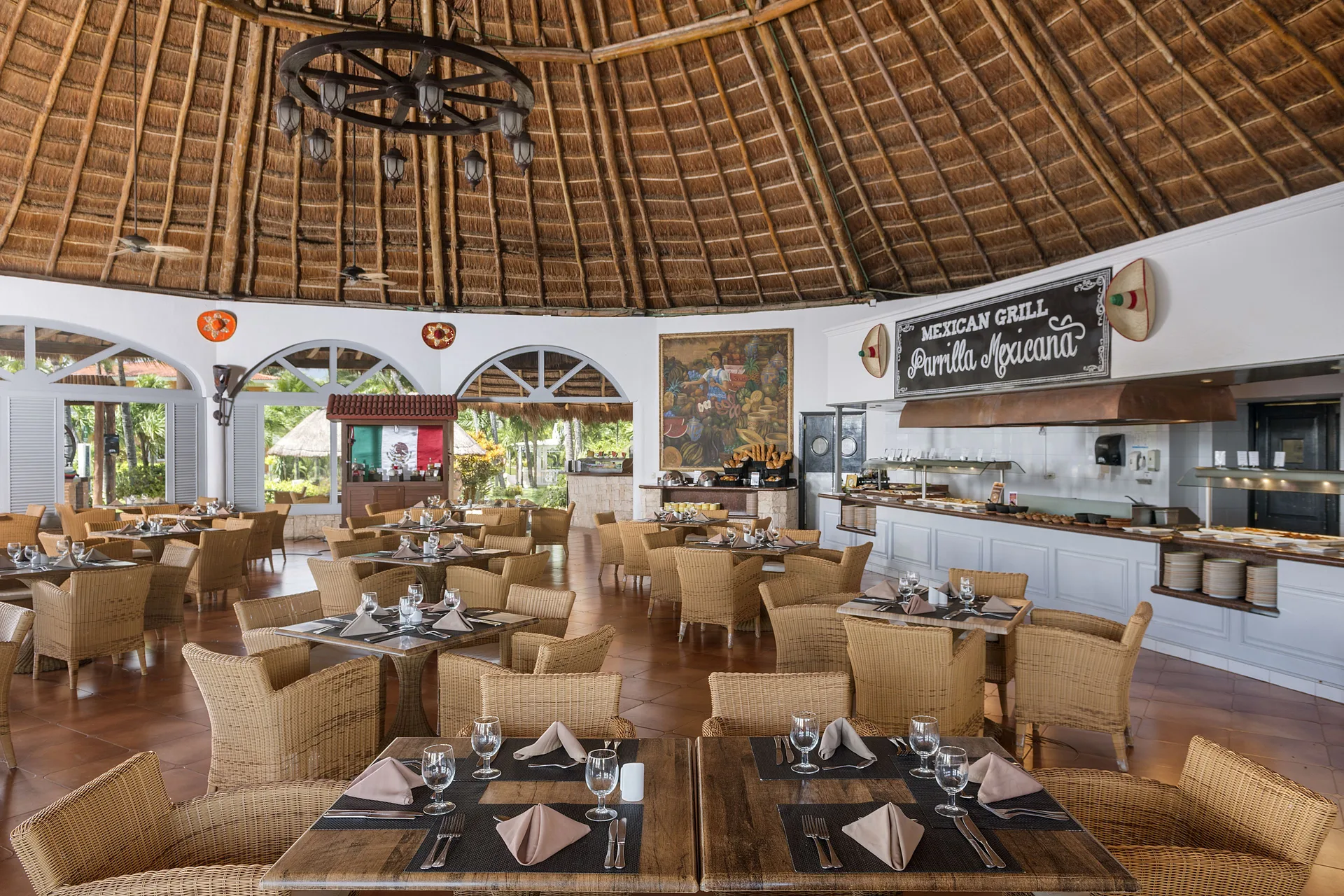 Open Mexican grill dining room with thatched ceiling at Ocean Maya Royale.