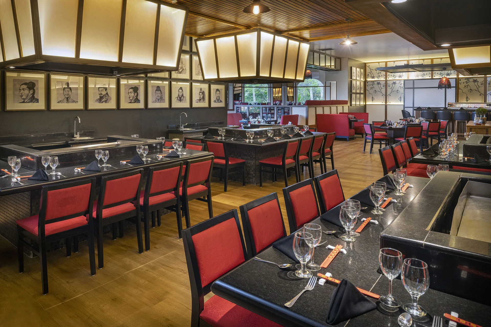 Asian-style dining room with cooking stations and red chairs at Ocean Maya Royale.