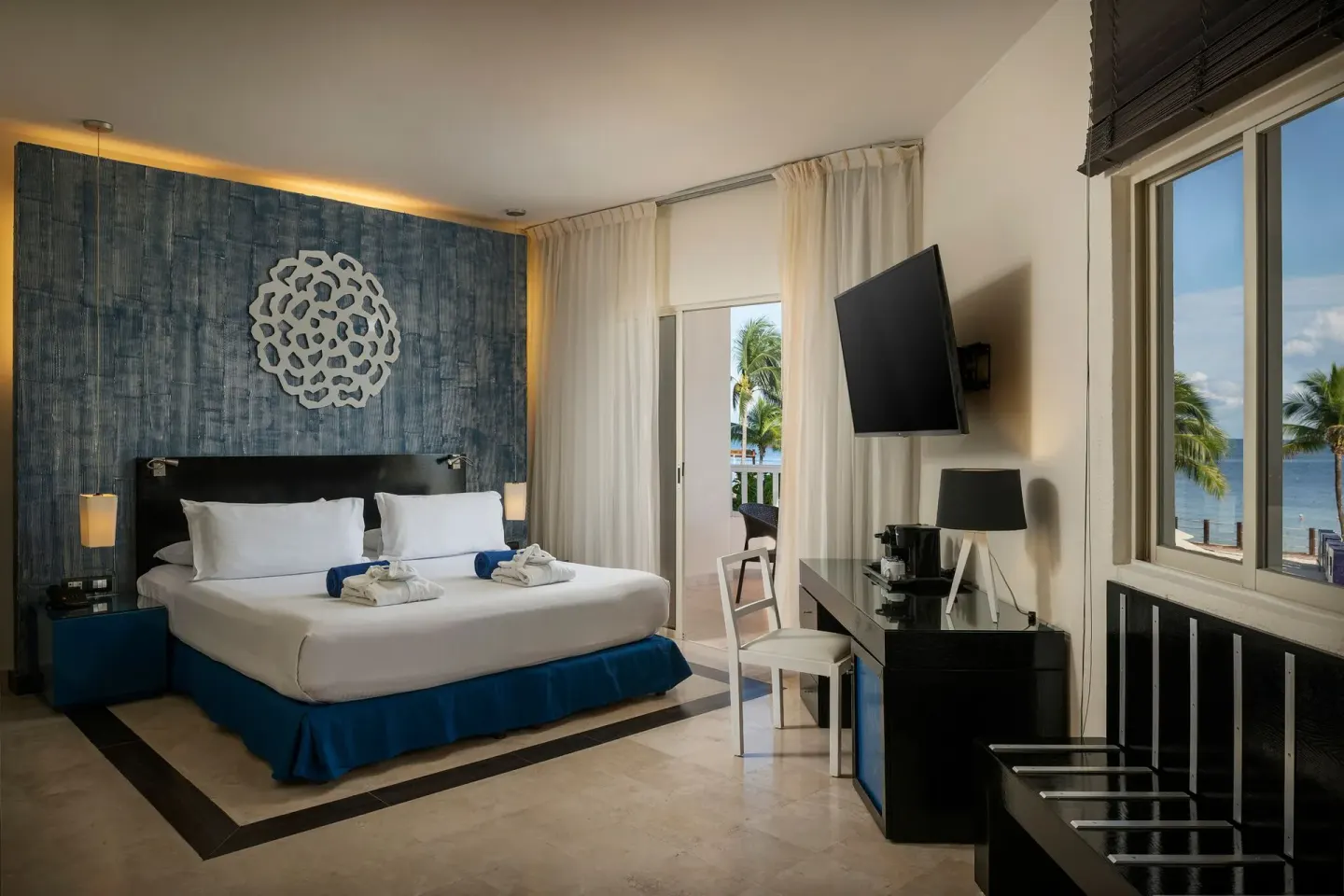 Privilege Junior Suite king bed with ocean-facing windows at Ocean Maya Royale.