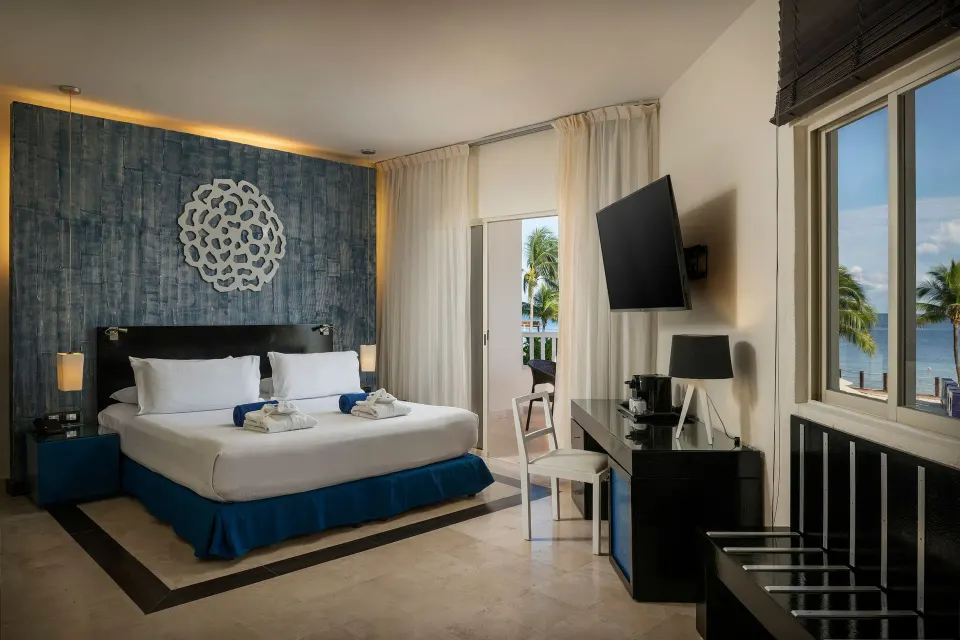 Privilege Junior Suite king bed with ocean-facing windows at Ocean Maya Royale.