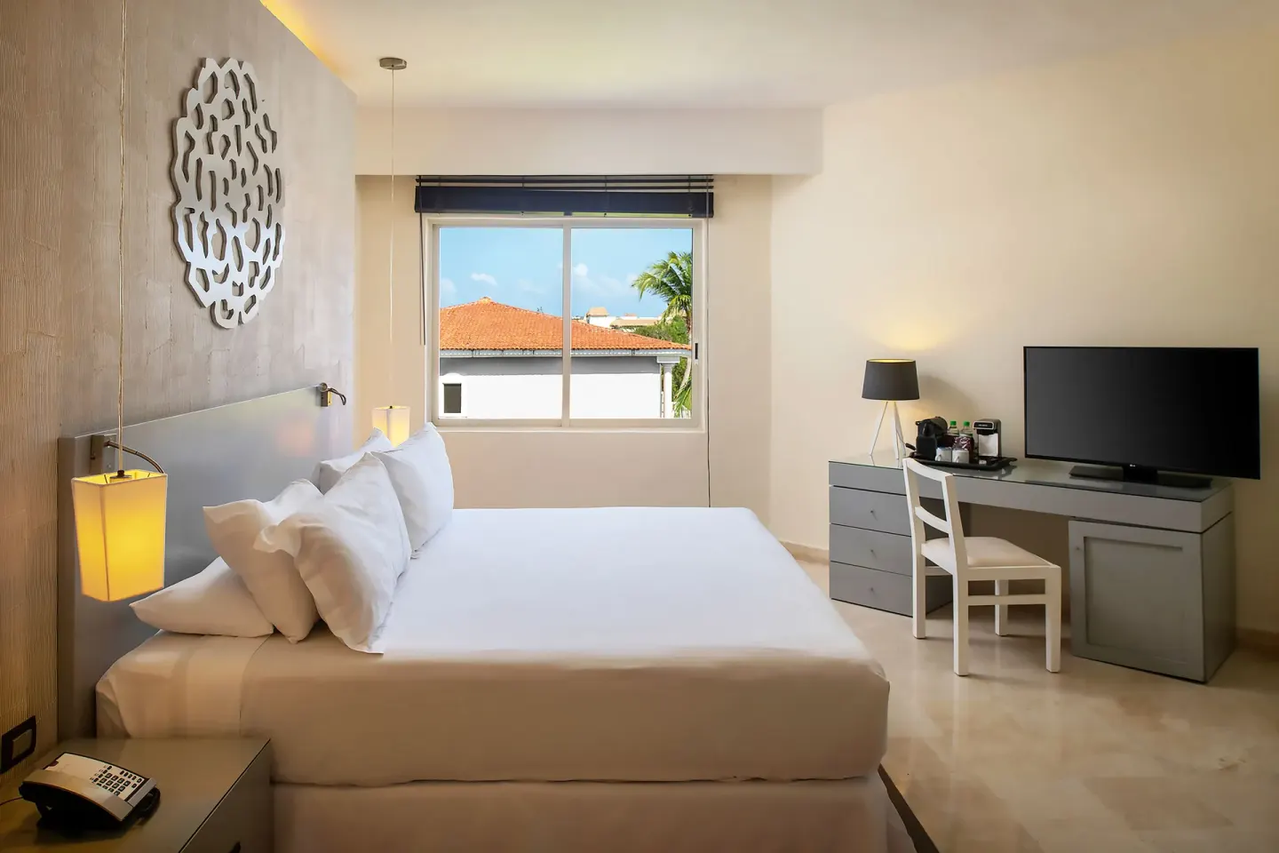 Privilege Romance Suite bedroom with king bed and desk at Ocean Maya Royale.