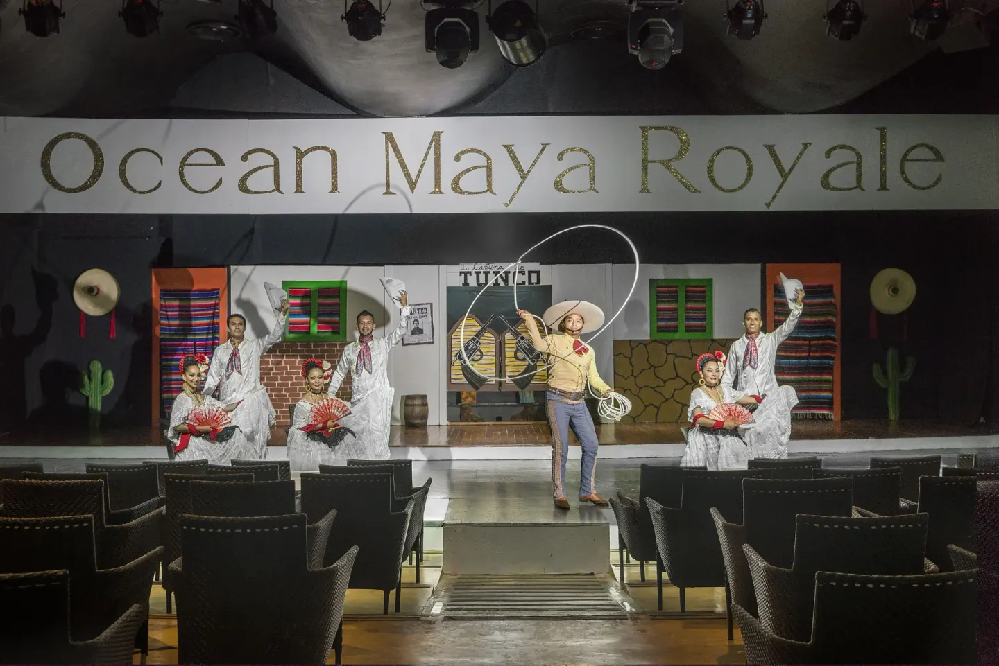 Stage show with dancers and resort sign at Ocean Maya Royale.