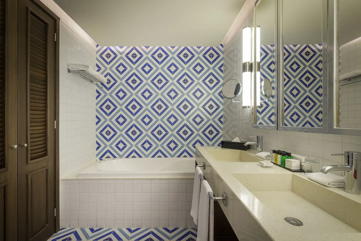 Bathroom with bathtub, double vanity, and blue patterned tile at Ocean Riviera Paradise.