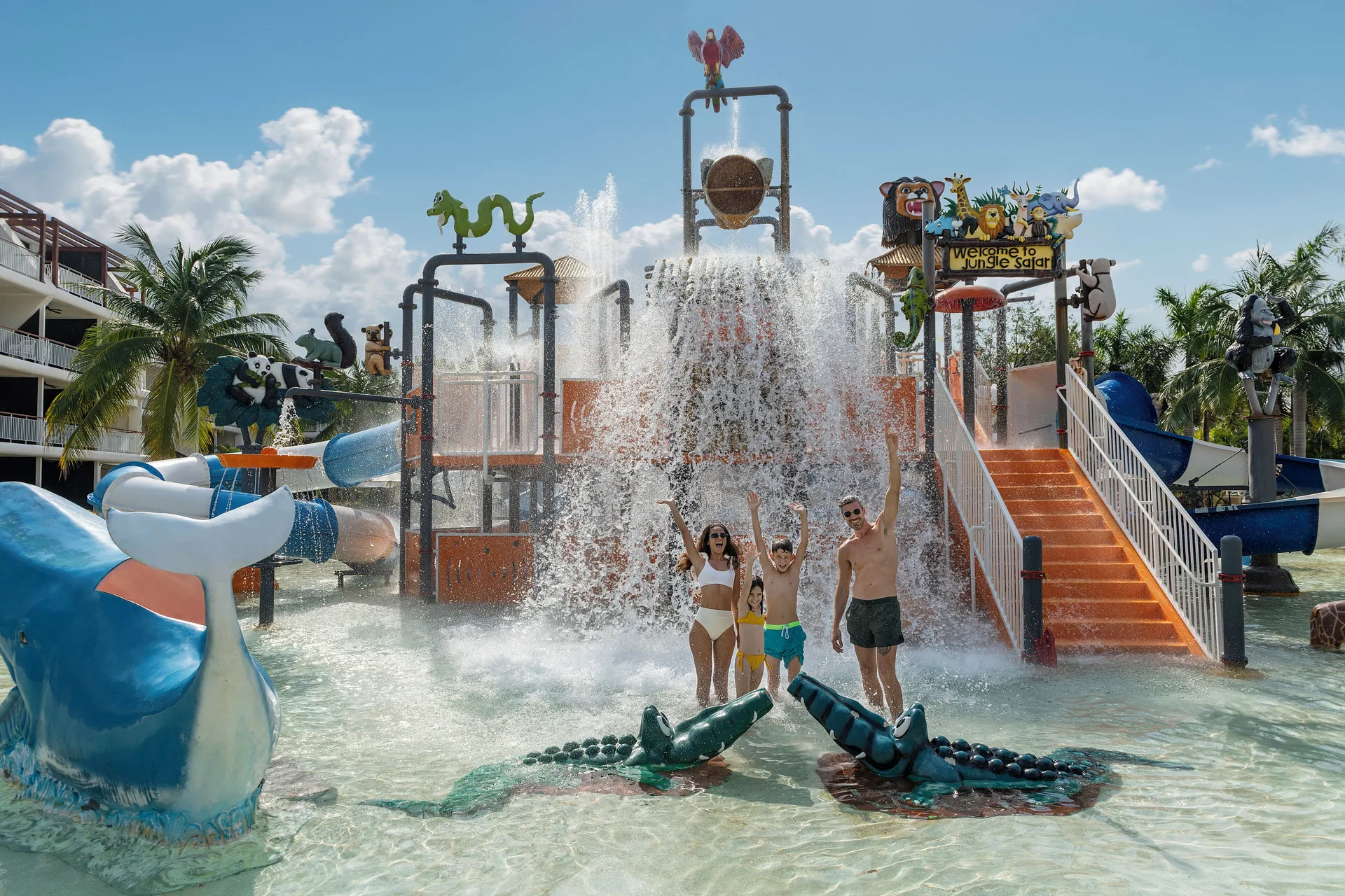 Family in children’s water park with tipping bucket and slides at Ocean Riviera Paradise.