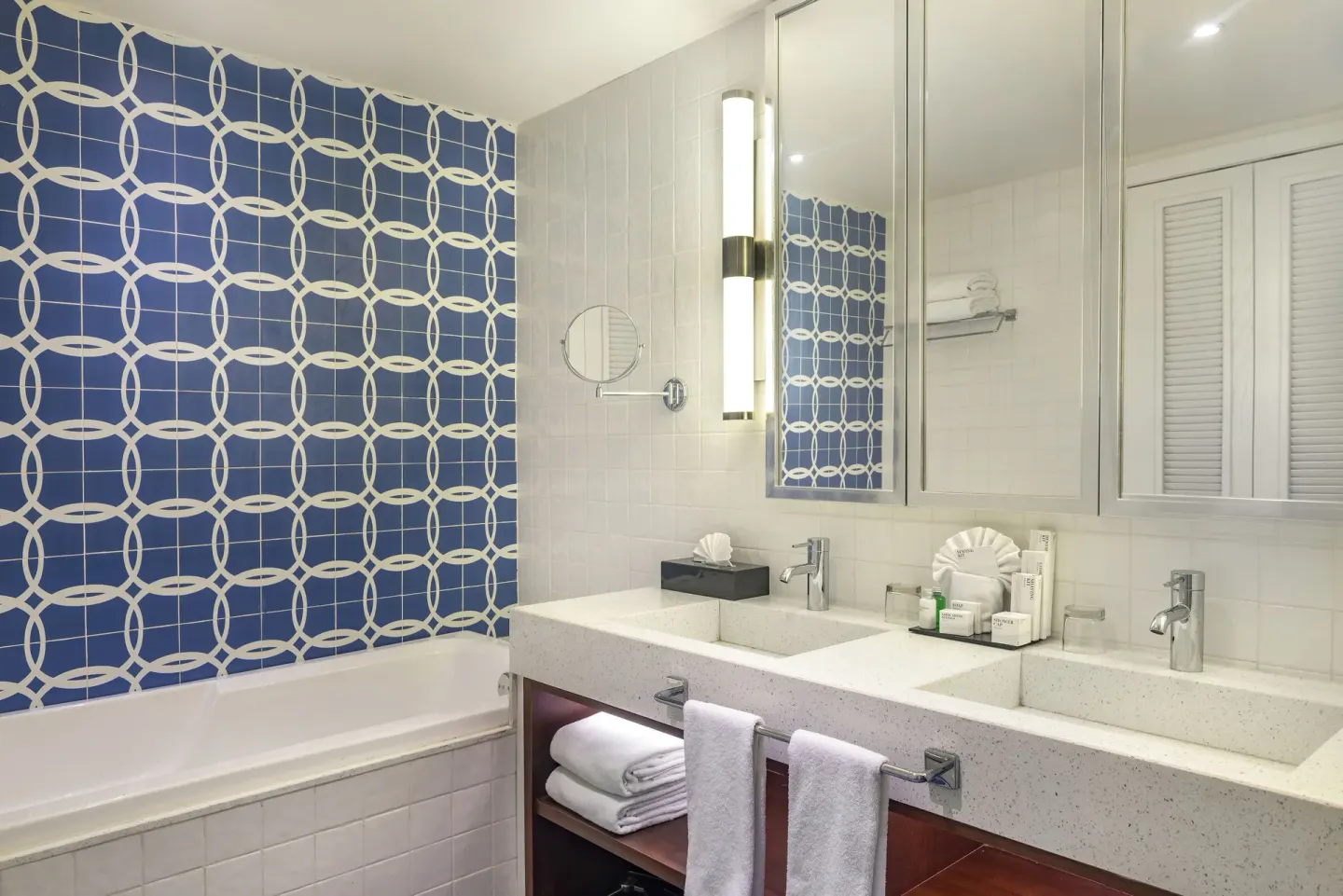 Bathroom with double vanity and blue tiled tub wall at Ocean Riviera Paradise.