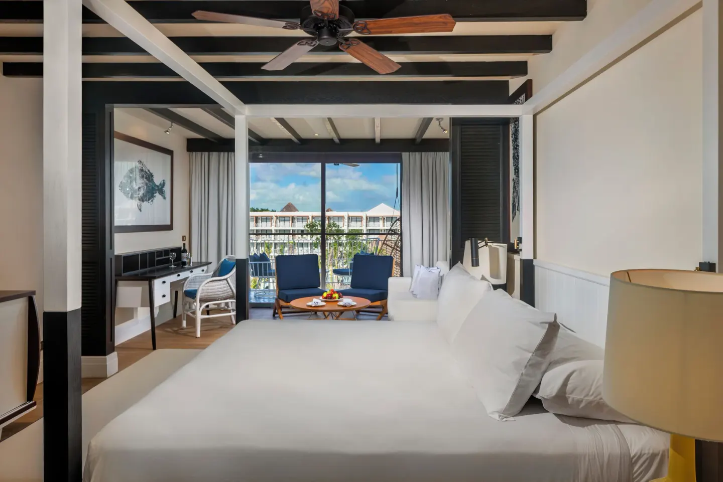 King bed guest room with balcony lounge at Ocean Riviera Paradise.