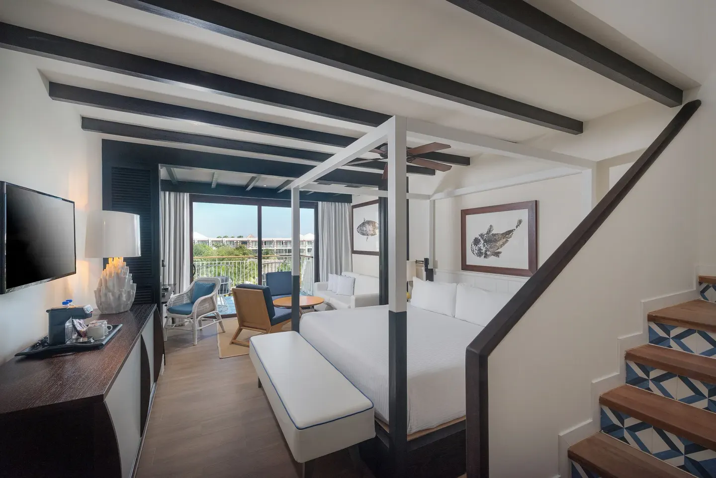 Loft-style guest room with king bed, stairs, and balcony at Ocean Riviera Paradise.