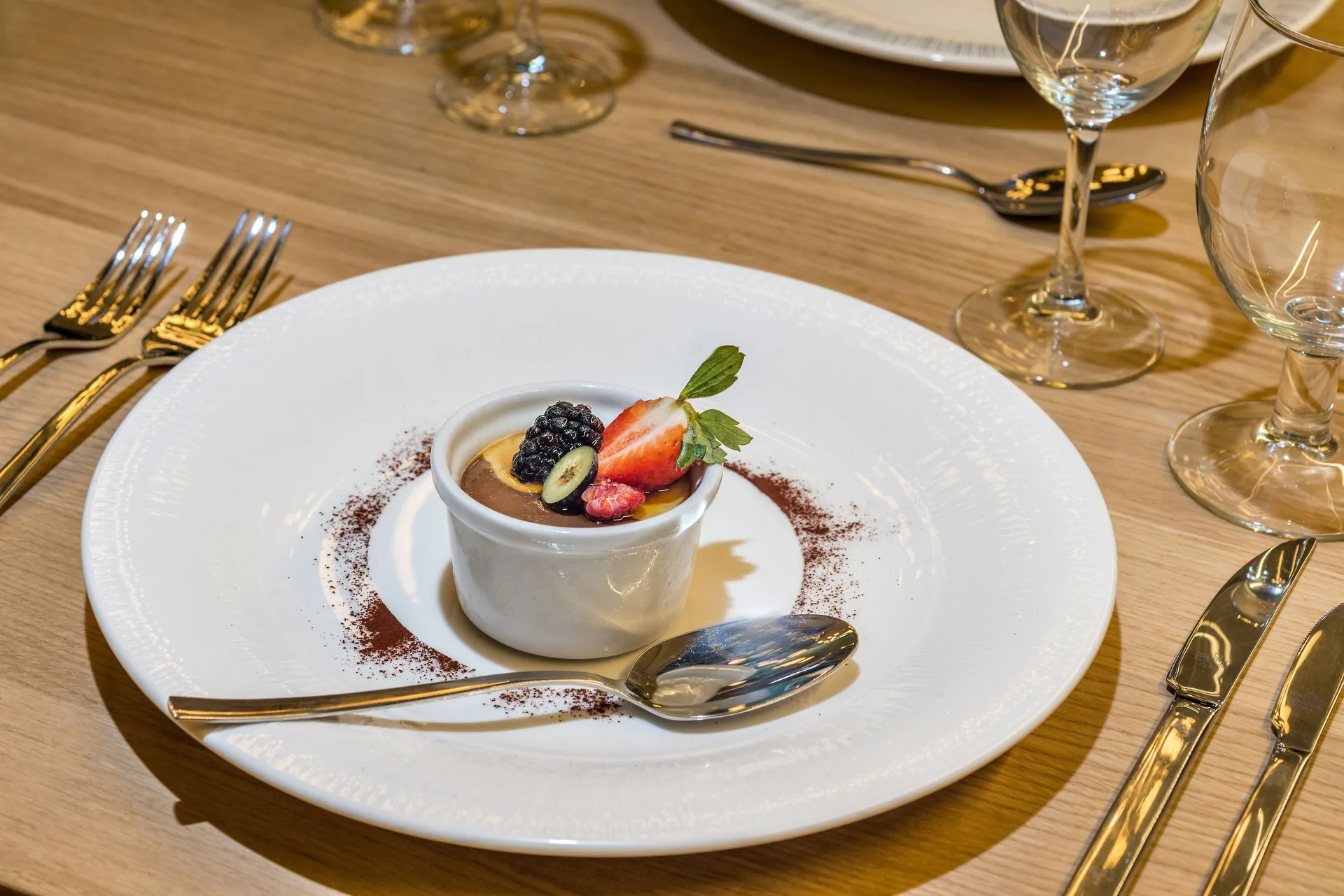 Plated chocolate dessert with berries on a dining table at Ocean Riviera Paradise.