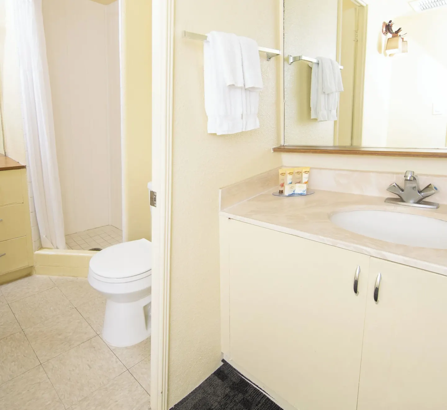 Bathroom vanity, towels, toilet, and shower at Ohia Waikiki Studio Suites.