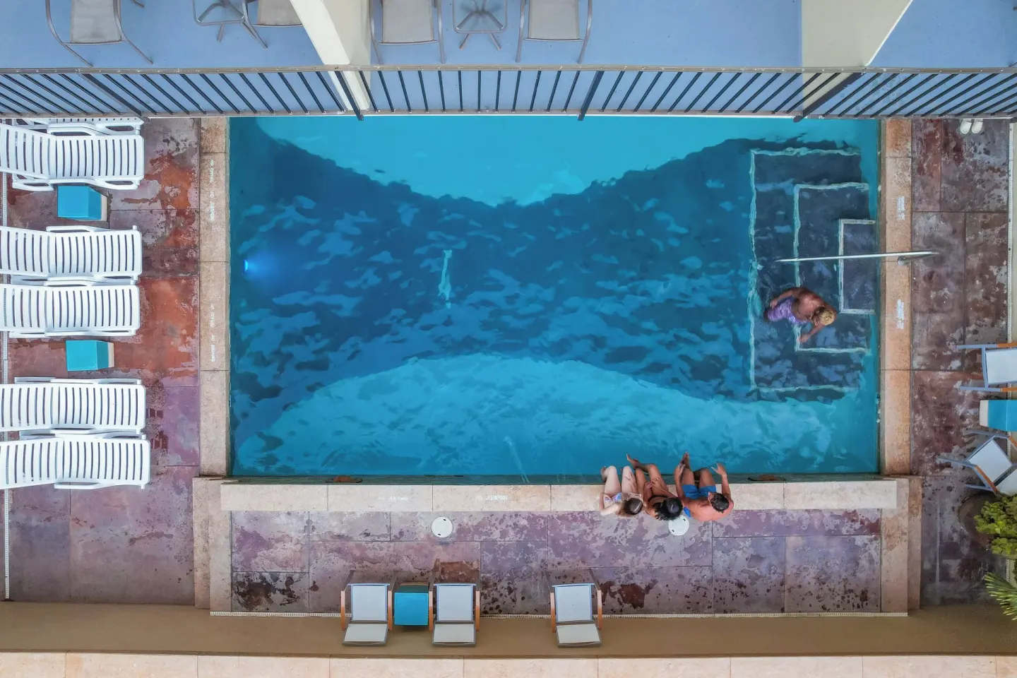Overhead view of the pool deck and swimmers at Ohia Waikiki Studio Suites.