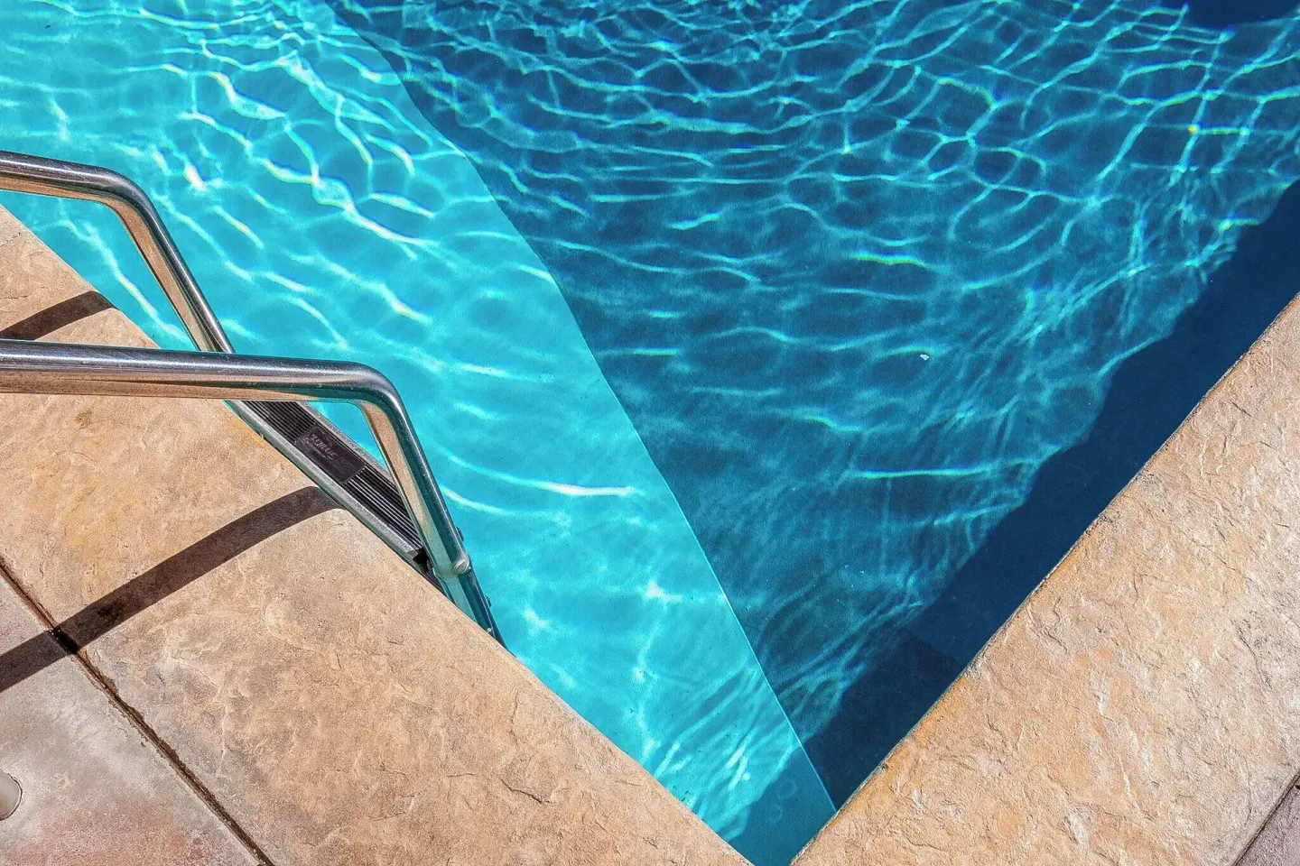 Close-up of pool steps and blue water at Ohia Waikiki Studio Suites.