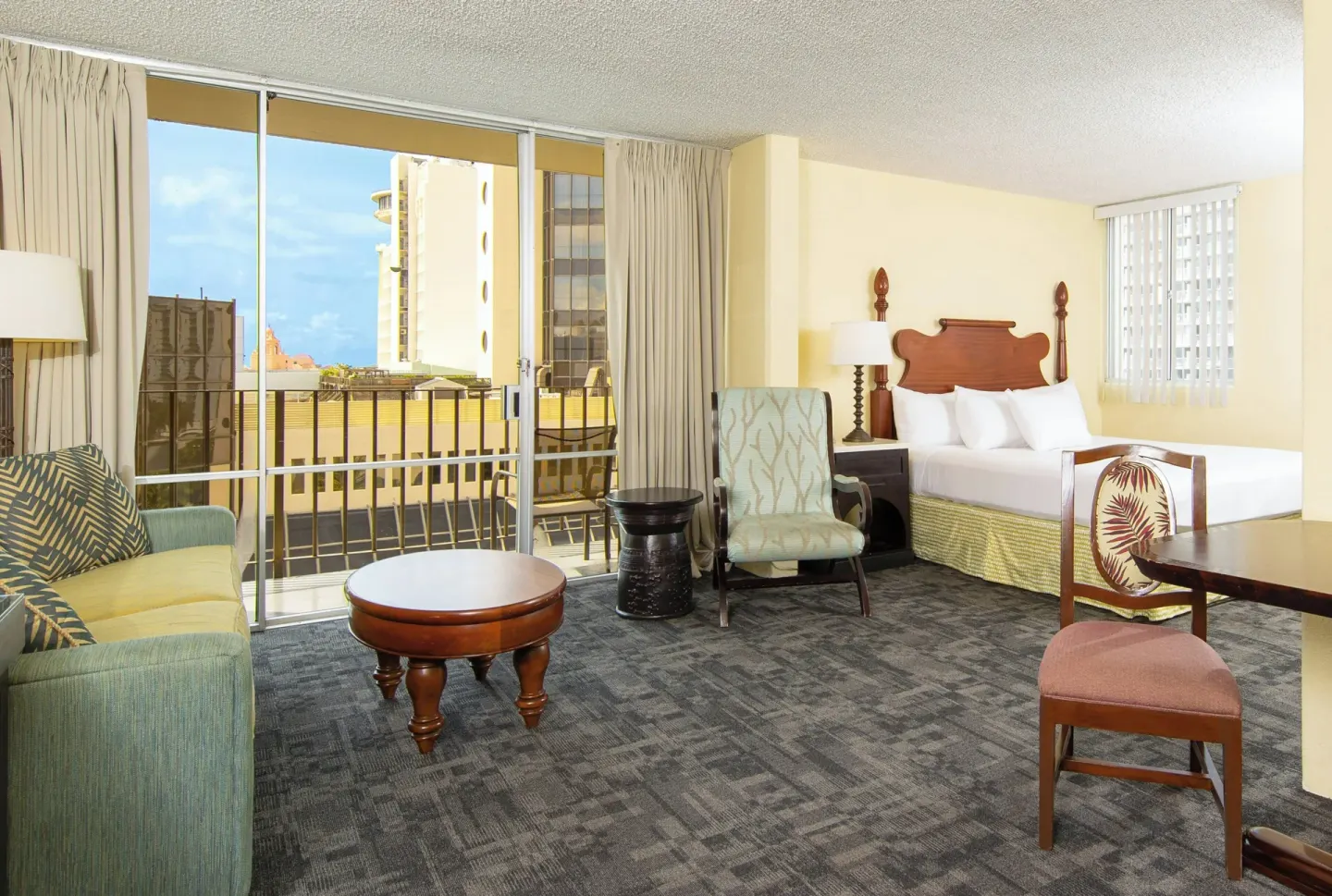 City View Suite with bed, sitting area, and balcony at Ohia Waikiki Studio Suites.