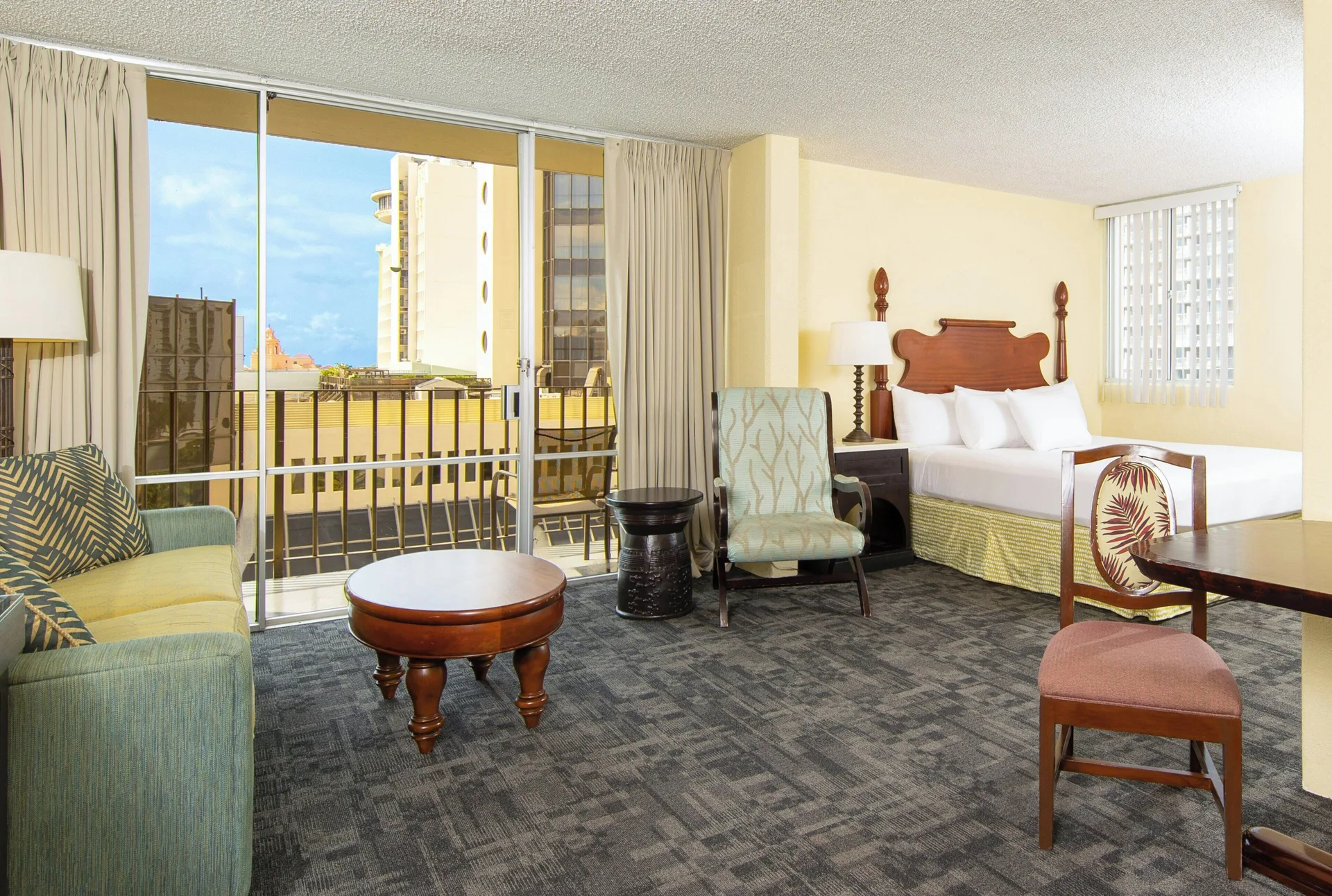 City View Suite with bed, sitting area, and balcony at Ohia Waikiki Studio Suites.