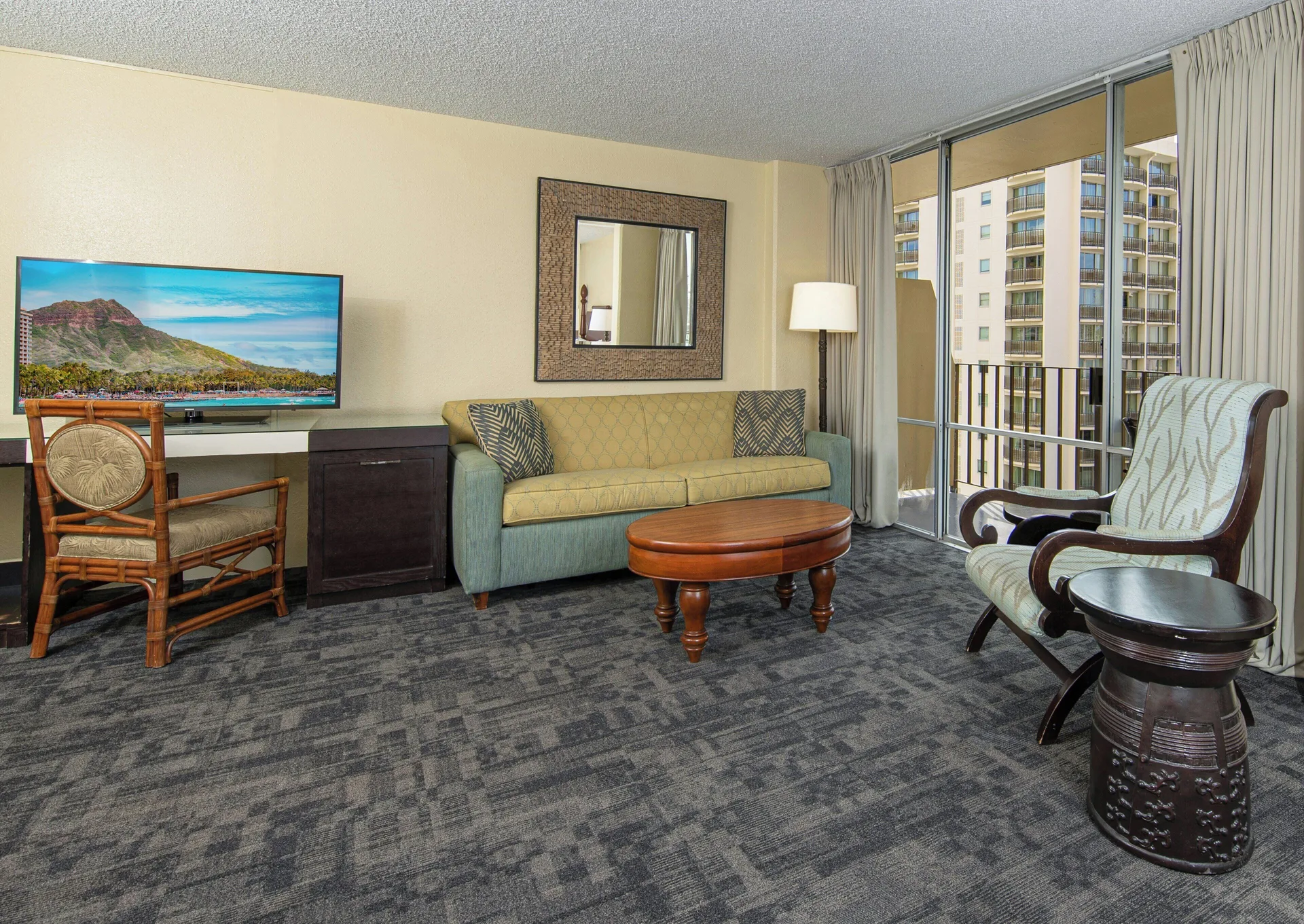 Living area in a City View Suite with balcony at Ohia Waikiki Studio Suites.