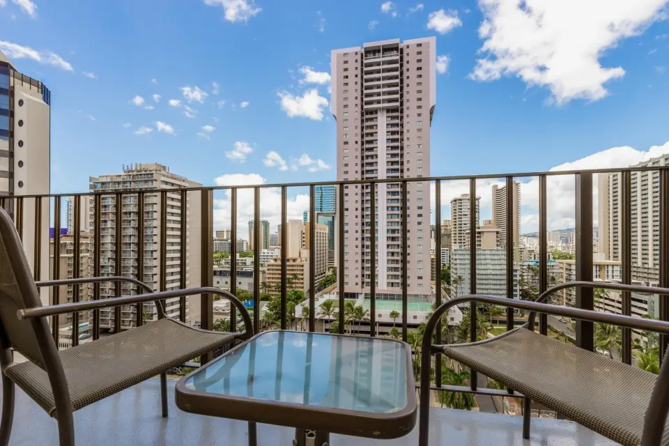 Balcony seating with a city skyline view at Ohia Waikiki Studio Suites.