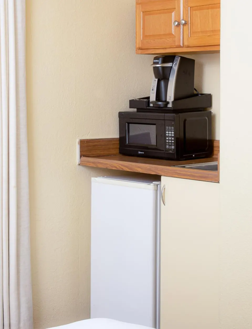 Kitchen area with mini fridge, microwave, and coffee maker at Ohia Waikiki Studio Suites.